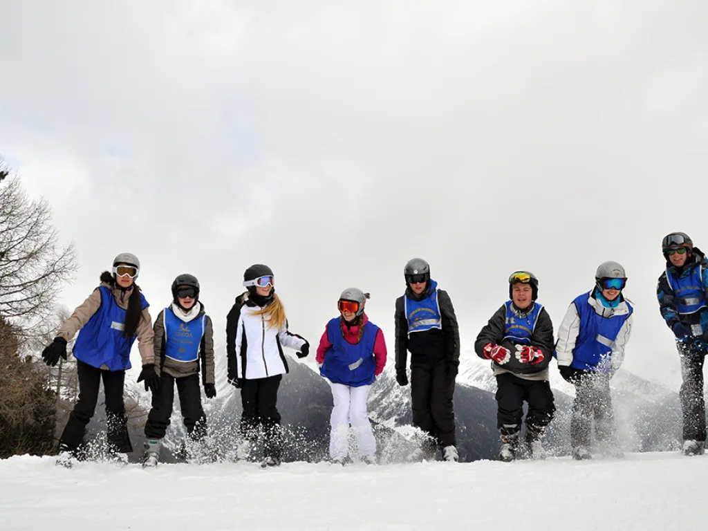 Skigruppe steht in einer Reihe vor dem Nebel.